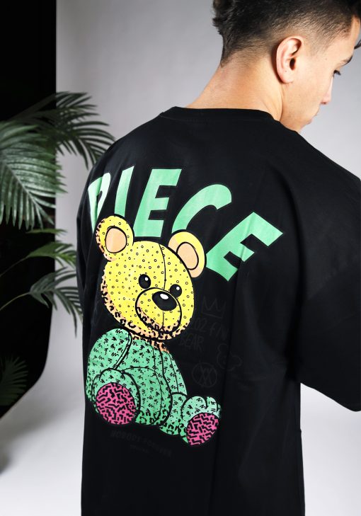 Close-up van de achterkant van een heren T-shirt in zwarte kleur. Het T-shirt is voorzien van groene tekst en een beer op de achterkant.