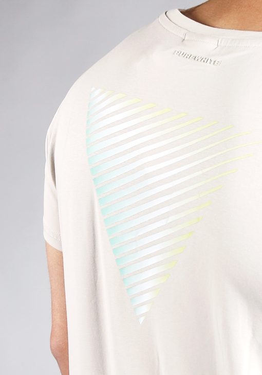Close up achteraanzicht van model gekleed in zandkleurig t-shirt met gestreepte driehoek print op de rug en het kleine logo op de borst. De prints hebben een faded kleur van mintgroen, naar wit, tot geel.