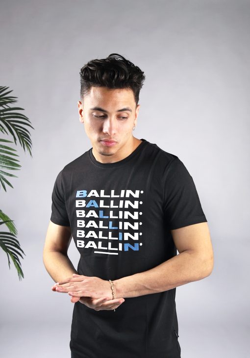 Vooraanzicht van model gekleed in zwart t-shirt met zes keer de witte tekst Ballin op de voorkant. Diagonaal zijn de letters een voor een blauw en maken ook zo het woord Ballin.