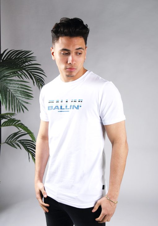 Schuin vooraanzicht van model gekleed in wit t-shirt met het Ballin drop logo in verschillende blauwe tinten op de borst.