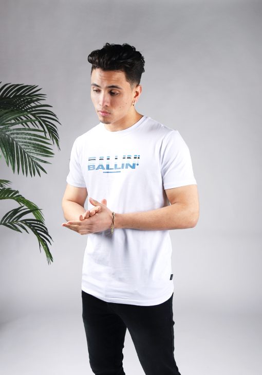 Vooraanzicht van model gekleed in wit t-shirt met het Ballin drop logo in verschillende blauwe tinten op de borst.