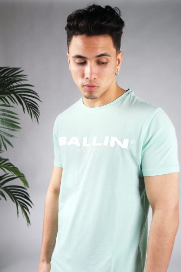 Vooraanzicht van model gekleed in mintgroen t-shirt met de witte tekst Ballin Amsterdam op de voorkant.