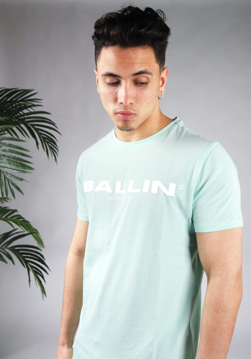 Vooraanzicht van model gekleed in mintgroen t-shirt met de witte tekst Ballin Amsterdam op de voorkant.