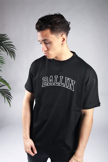 Vooraanzicht van model gekleed in zwart t-shirt met relaxed fit en de tekst Ballin in university stijl op de borst in het wit.