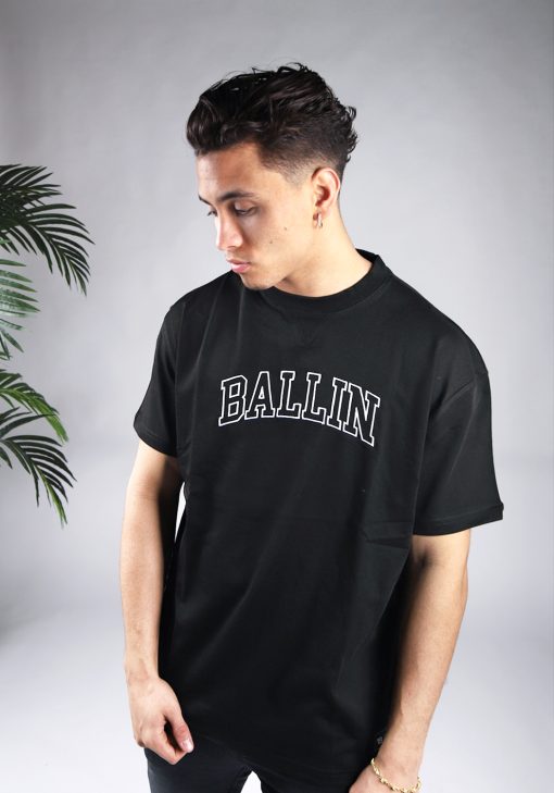Vooraanzicht van model gekleed in zwart t-shirt met relaxed fit en de tekst Ballin in university stijl op de borst in het wit.