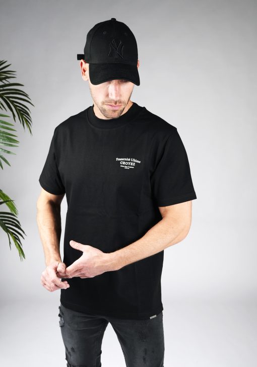 Vooraanzicht van heren T-shirt in zwarte kleur, met een ronde hals en een box fit pasvorm. Het T-shirt is voorzien van witte tekst op de linkerborst.