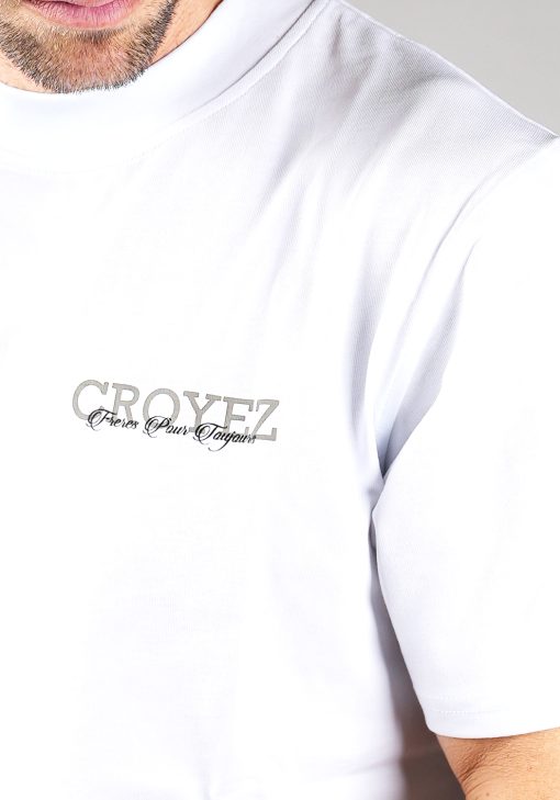 Close-up van heren T-shirt in witte kleur, met een ronde hals en een box fit pasvorm. Het T-shirt is voorzien van zwarte en grijze tekst op de linkerborst.
