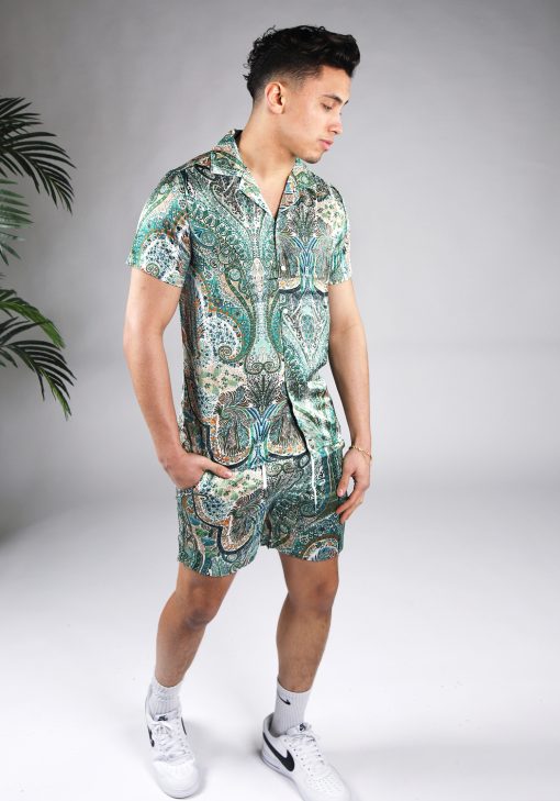 Vooraanzicht van model gekleed in jungle set met drukke gekleurde print. De set bestaat uit shorts en een blouse met korte mouwen.