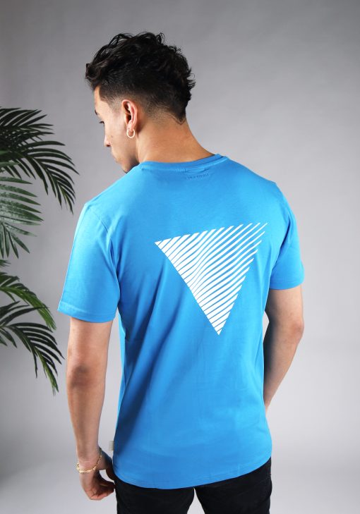 Achteraanzicht van model gekleed in felblauw t-shirt met wit gestreepte driehoek print op de rug en het kleine logo op de borst.