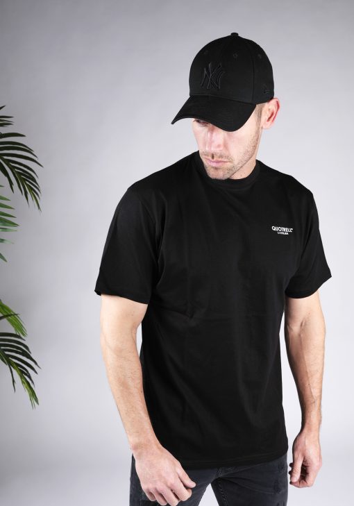 Rechter vooraanzicht van heren T-shirt in zwarte kleur, met ronde hals en een relaxed fit pasvorm. Het T-shirt is voorzien van het QUOTRELL-logo in witte kleur op de borst.