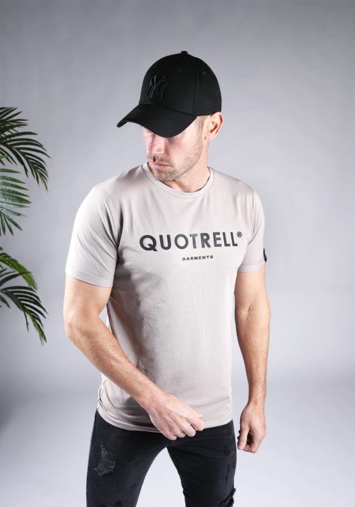 Schuin vooraanzicht van heren T-shirt in taupe kleur, met ronde hals en een slim fit pasvorm. Het T-shirt is voorzien van het QUOTRELL-logo in zwarte kleur op de borst.
