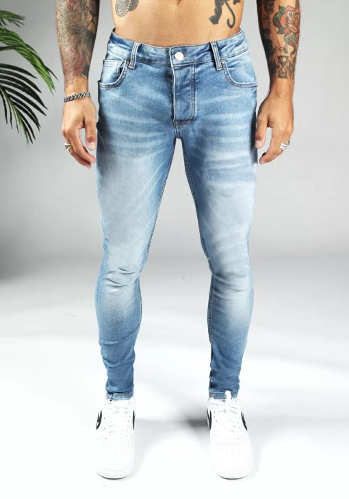 Voorkant lichtblauwe heren skinny jeans van stretch stof. Voorzien van vier zakken, knoopsluiting en riemlussen.