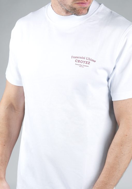 Close-up van heren T-shirt in witte kleur, met een ronde hals en een box fit pasvorm. Het T-shirt is voorzien van rode tekst op de linkerborst.