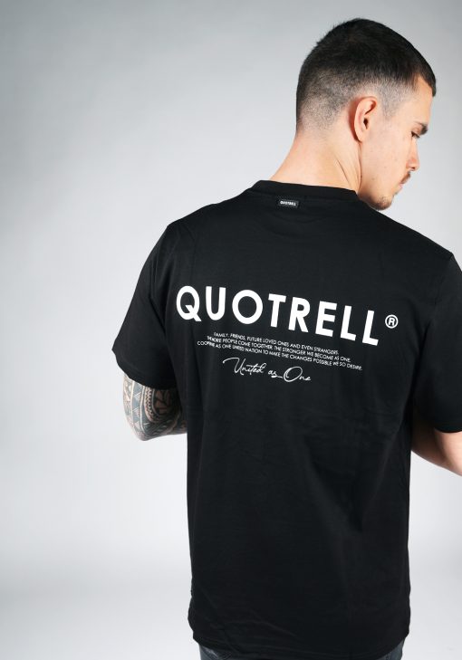 Achteraanzicht van model gekleed in een heren T-shirt in zwarte kleur en met ronde hals. Het T-shirt is voorzien van het QUOTRELL-logo en witte tekst op de rug.