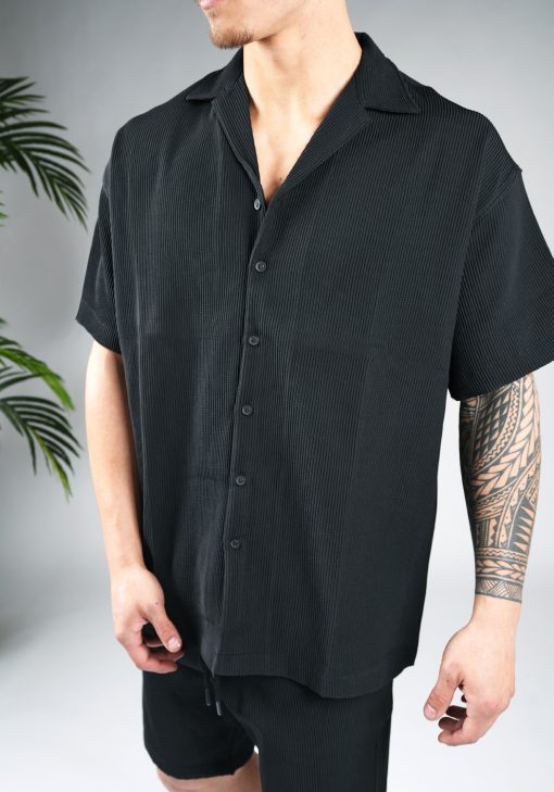 Zwarte heren blouse van ribstof, met korte mouwen en afgewerkt met knoopjes en V-hals.