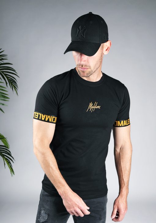 Vooraanzicht van model gekleed in zwart t-shirt met het gouden Malelions logo in het midden van de borst, en de gouden tekst Malelions rondom de mouwen.